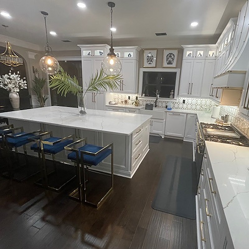 Fully remodeled kitchen with white cabinets and quartz island after water damage restoration in a Georgia home
