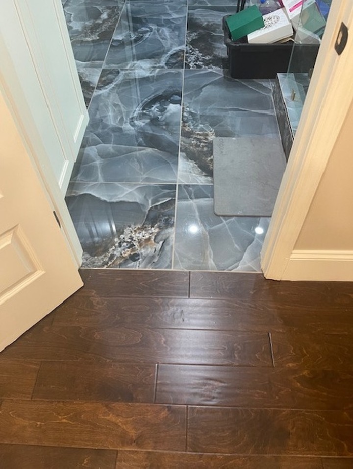 New tile-to-hardwood transition after water damage repair in a Georgia home