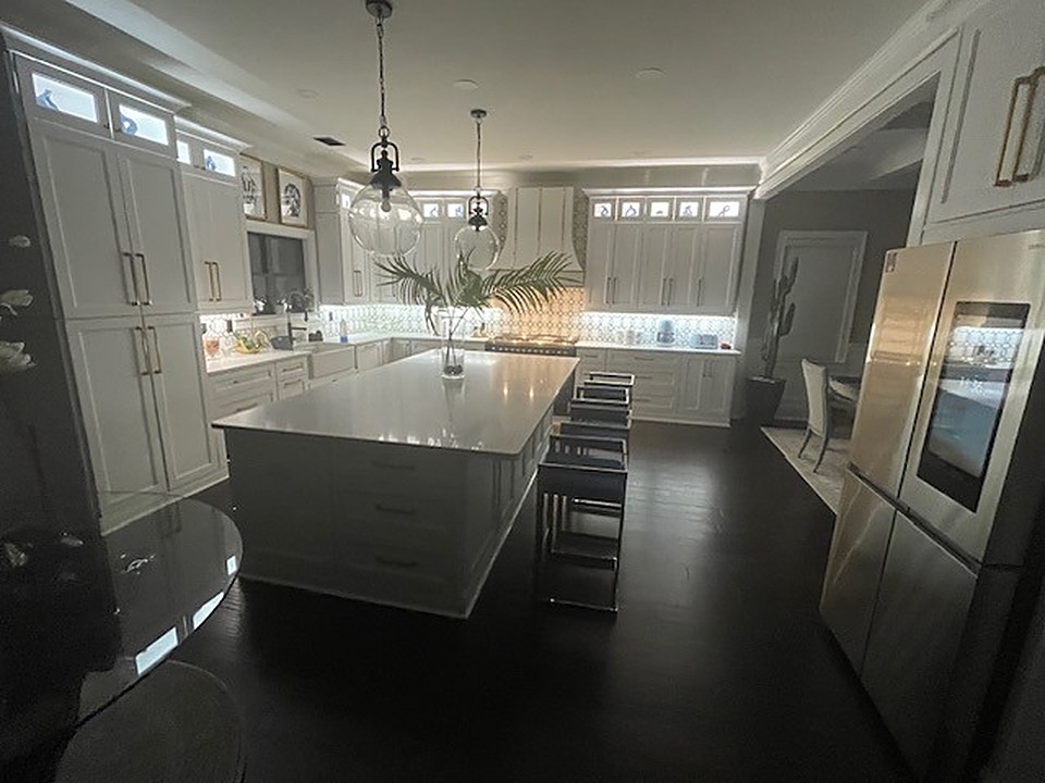 Finished kitchen with white cabinetry and quartz island after reconstruction