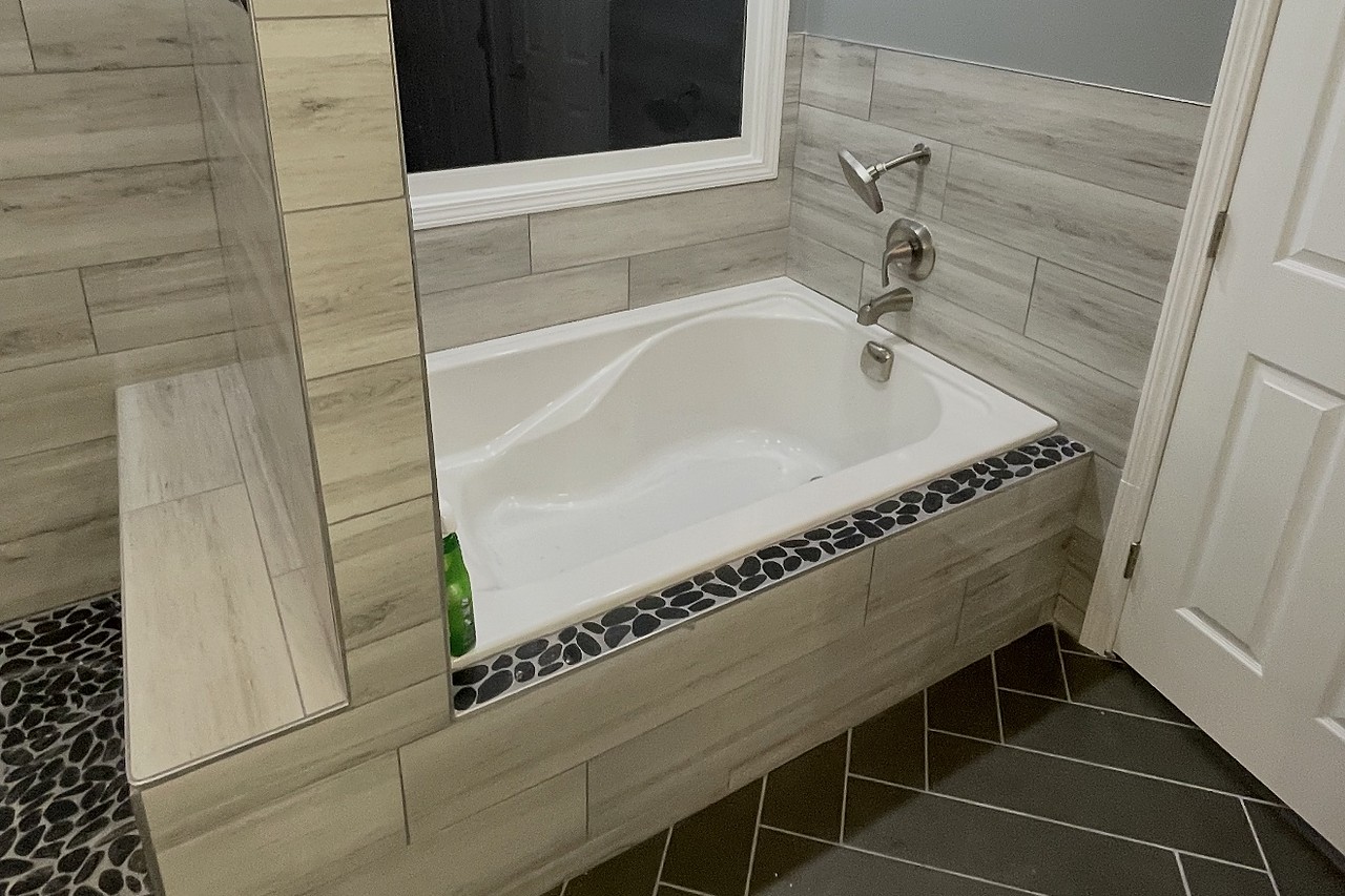 Rebuilt bathroom with new tub deck, tile surround, and herringbone floor